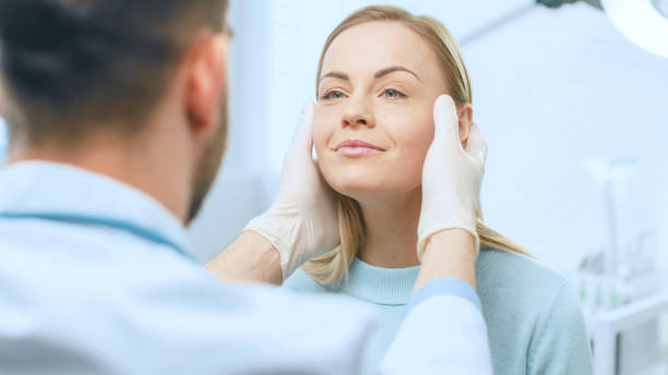 médico revisando rostro de mujer